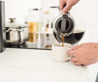 En person som heller kaffe i en kopp