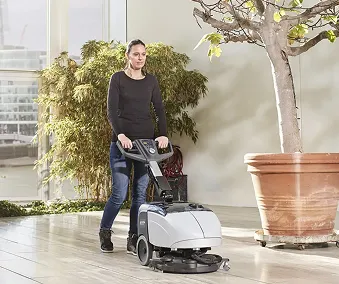 En person som bruker en gulvmaskin til å vaske gulv