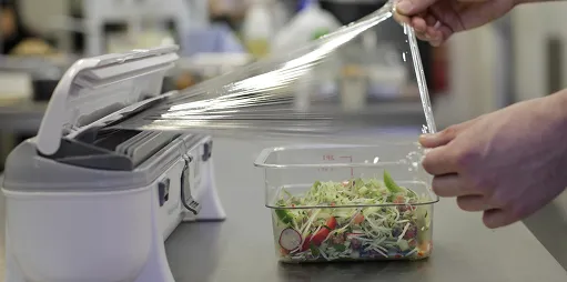 En person som tar ut en cling film fra en wrapmaster