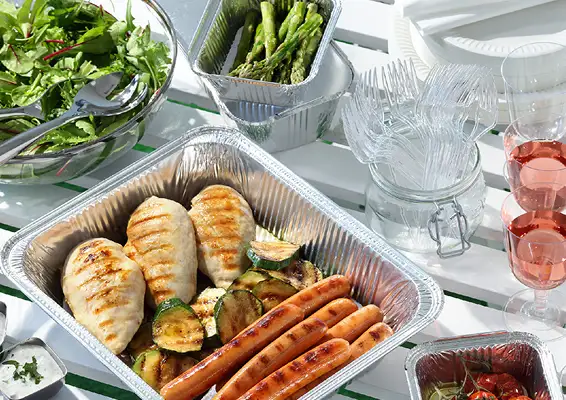 Ett bord fylt med mat og drikke i engangsemballasje